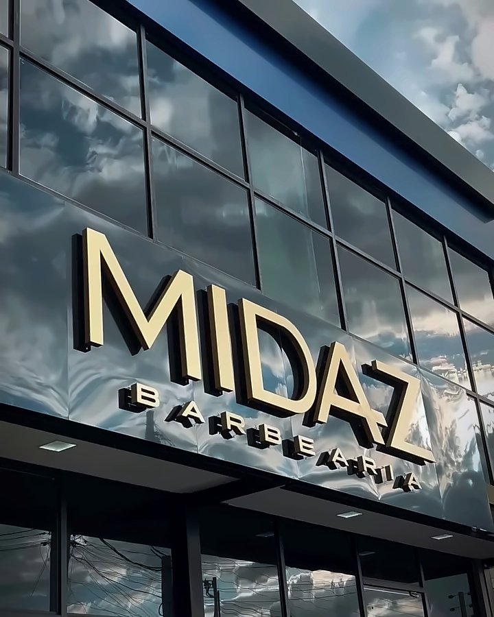 Fachada de vidro da Midaz com o letreiro dourado