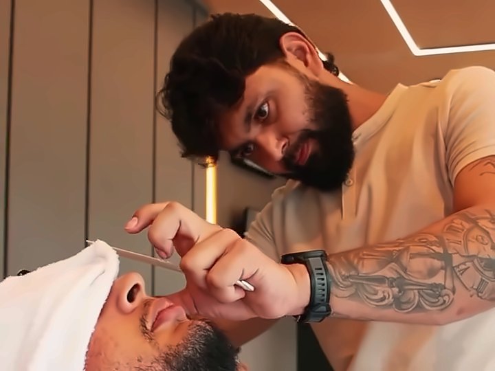 Barboterapia com toalha quente sobre o rosto do cliente
