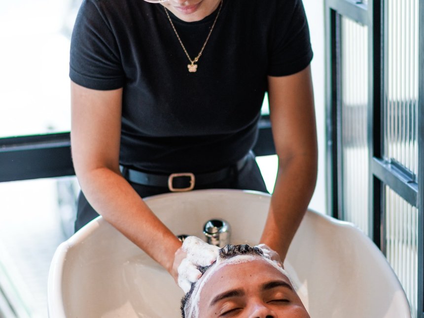 Lavagem de cabelo no lavatório, com o cliente relaxado de olhos fechados